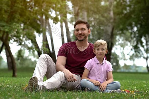 幸福的父亲和儿子一次采用公园,广告关于社会的支持为英文字母表的第19个字母