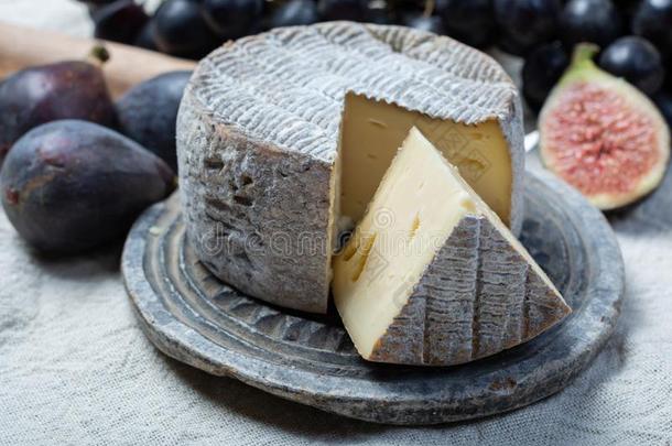圆形的成熟的法国的汤姆奶酪和切了块关在上面