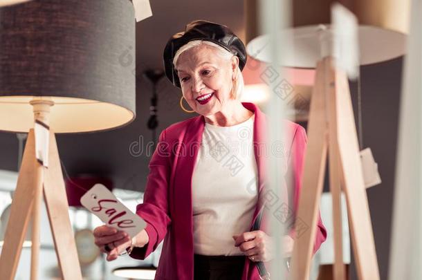 蓝色-漂洗迷人的上了年纪的女士微笑地有样子的在卖符号