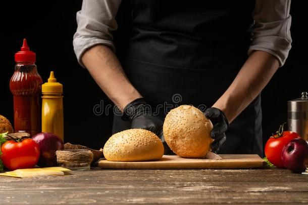 厨师准备新鲜的芝麻圆形的小面包或点心为汉堡包烹饪术,和i
