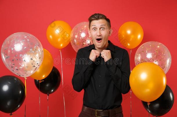 兴奋的幸福的年幼的男人采用典型的衬衫clench采用g拳,庆祝者