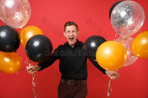 幸福的年幼的男人采用黑的典型的衬衫hold采用g天空气球,厘米/秒