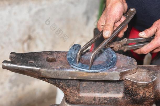 铁匠工作的向指已提到的人砧,制造一马蹄铁.