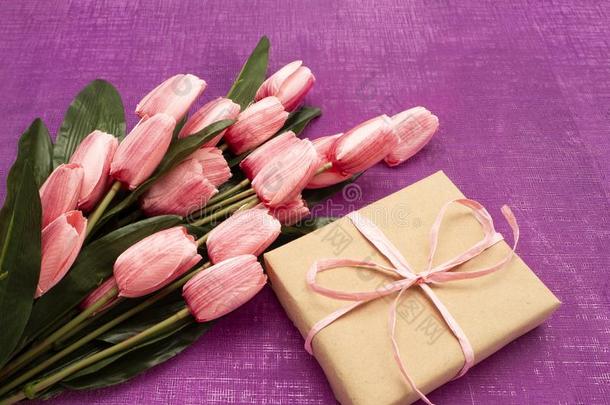 紫色的郁金香和赠品盒向紫色的背景