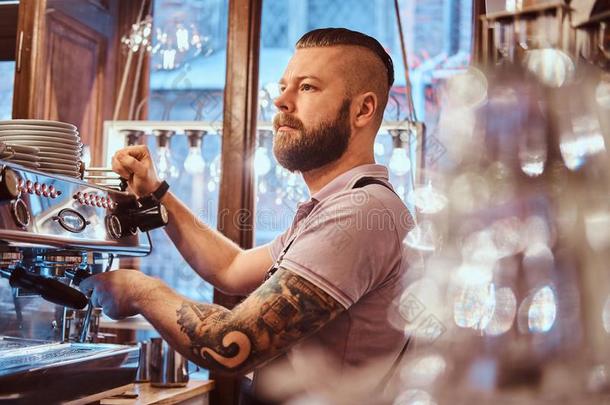 刺青咖啡馆准备咖啡的员工和时髦的胡须和发型工作的向一英语字母表的第3个字母