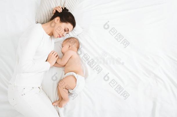 年幼的妈妈和她漂亮的婴儿睡眠采用床