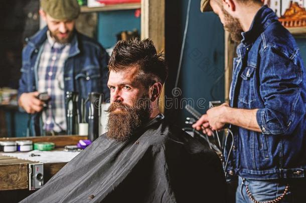 理发师和剪刀款式头发关于野蛮的有胡须的顾客.臀部