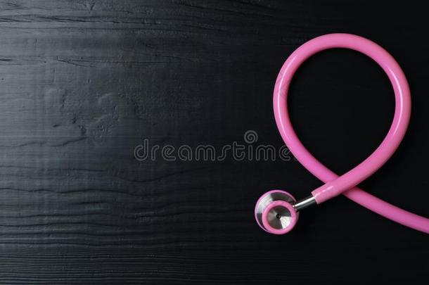 粉红色的听诊器折叠的喜欢察觉带向木制的后台