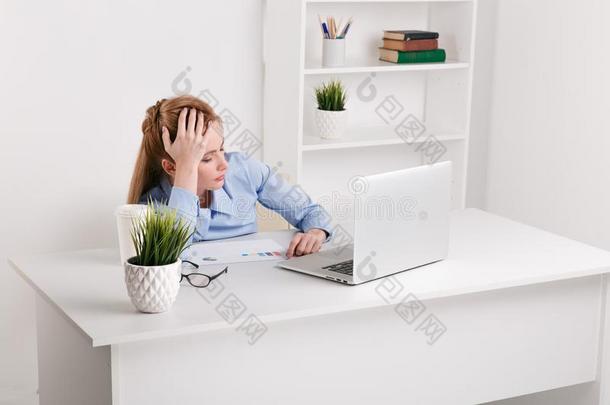 照片关于疲倦的女商人工作的便携式电脑.办公室女孩我是法蒂