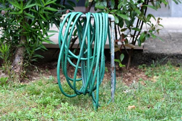 绿色的花园水软管有包装的大约金属管子被环绕着的机智