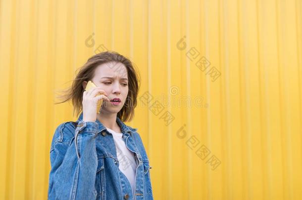 表现强烈情感的女孩采用一斜纹粗棉布j一cketspe一ks在旁边电话向指已提到的人b一ck