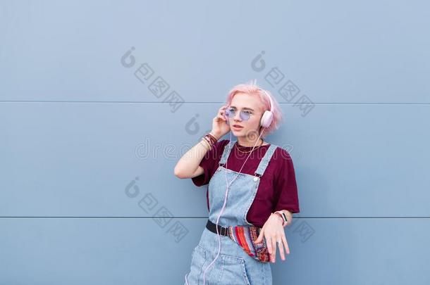 时髦的嬉皮士女孩和粉红色的头发看台向指已提到的人背景关于一