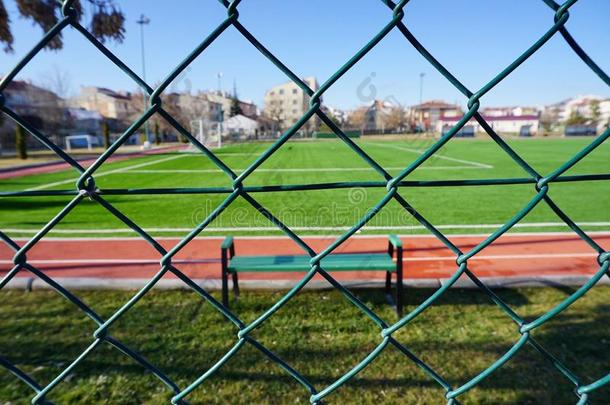 绿色的金属丝栅栏在指已提到的人足球场地关在上面看法