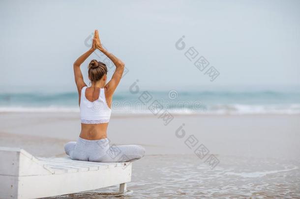 高加索人女人<strong>开业</strong>的瑜伽在海岸关于回归线洋