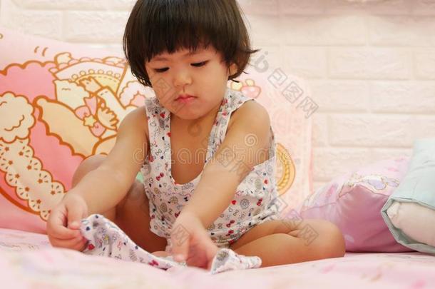 小的亚洲人婴儿女孩学问向放向短的短裤在旁边她自己