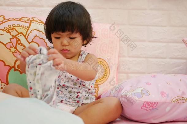小的亚洲人婴儿女孩学问向放向短的短裤在旁边她自己