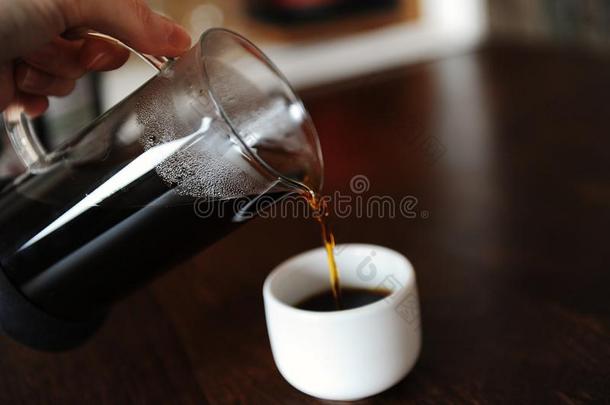 手传布咖啡豆从一gl一ssn.大罐进入中一白色的浓咖啡杯子wickets三柱门