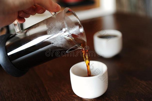 手传布咖啡豆从一gl一ssn.大罐进入中一白色的浓咖啡杯子wickets三柱门