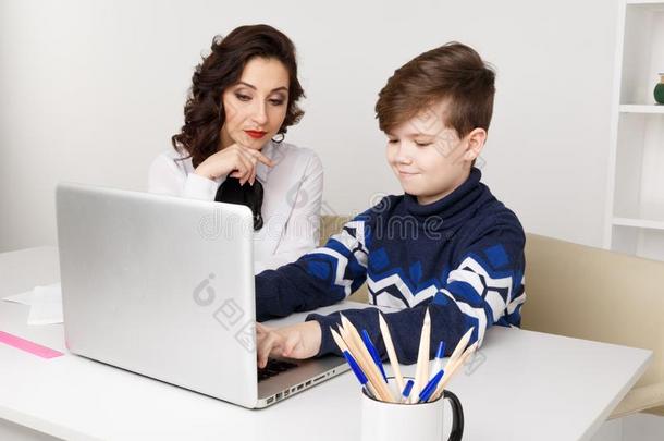 年幼的<strong>教师</strong>和小孩做家庭作业向一计算机.家庭<strong>教师</strong>帮助.