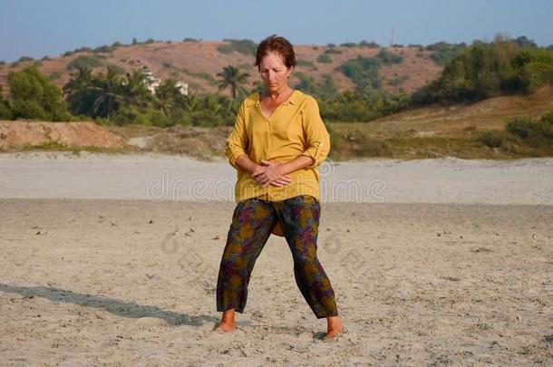 较高的女人开业的根本体育的在沙的海滩