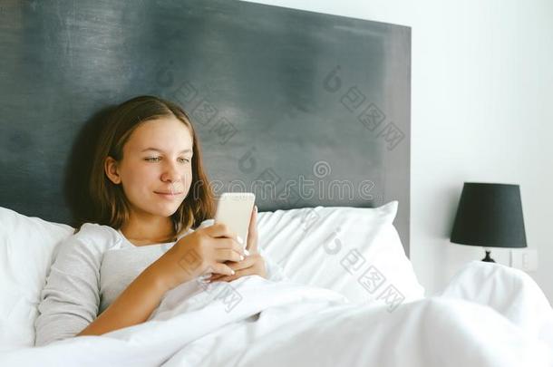 12-14年少女女孩使用智能手机采用床