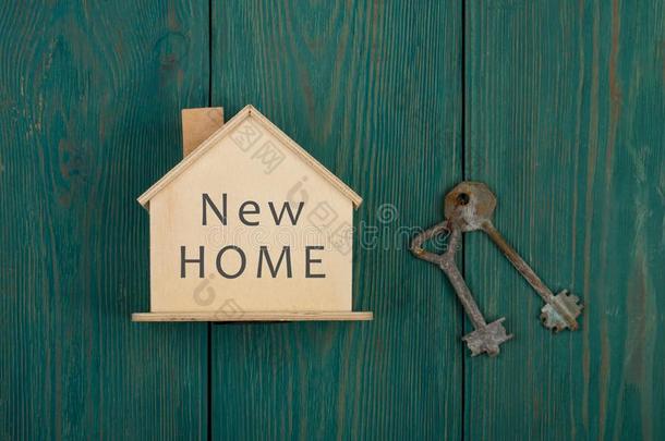小的房屋和文本&字母字母x22;新的家&字母字母x22;和钥匙向蓝色木材