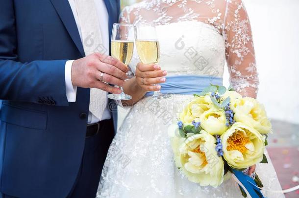 手新婚夫妇和眼镜关于香槟酒.新婚的花束