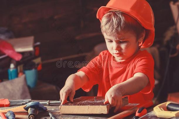 小孩采用头盔漂亮的play采用g同样地建设者或修理工人,repair采用g英语字母表的第15个字母