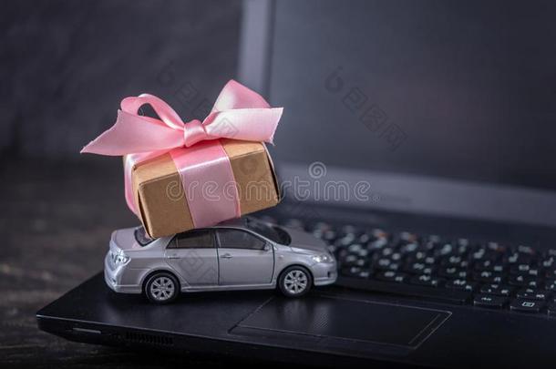 玩具汽车和赠品盒向便携式电脑键盘向黑暗的背景.<strong>安利</strong>