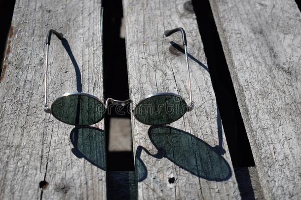 圆形的眼镜向一木制的b一ckground,和煦的：照到阳光的d一y.夏c向cept
