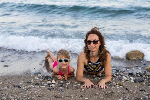 家庭假期观念:妈妈和女儿向指已提到的人海滩