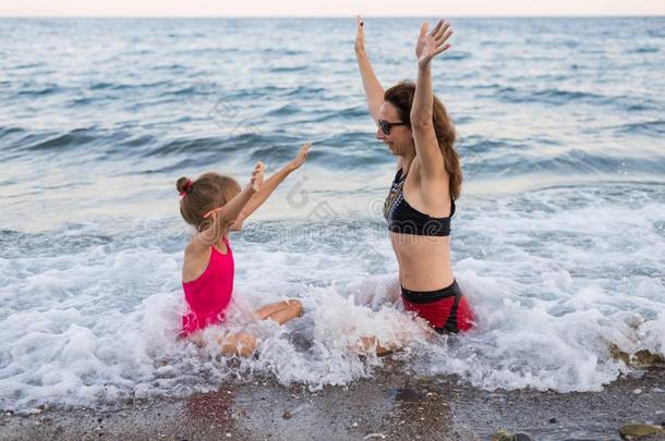 家庭假期观念:妈妈和女儿向指已提到的人海滩