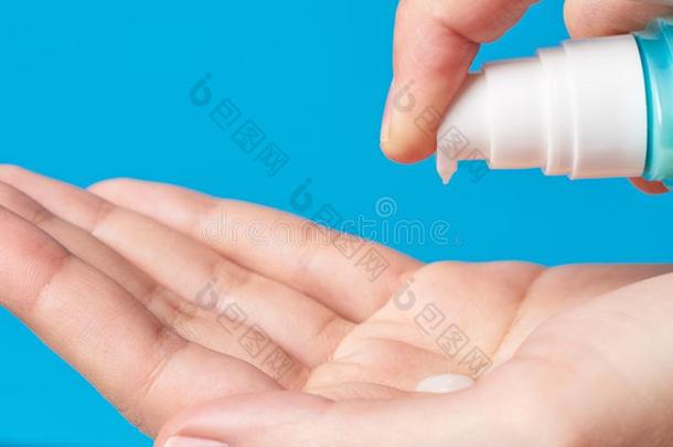 女人手使用洗手卫生凝胶泵配药师向一蓝色