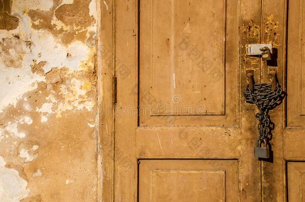 老的木制的门上锁的和生锈的链子和挂锁