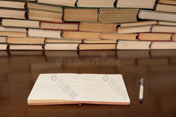 空白的敞开的便条簿和笔向指已提到的人表和书