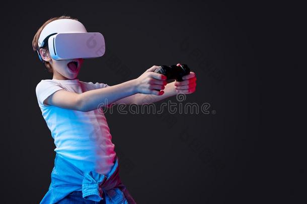 吃惊的小孩采用VirtualReality虚拟现实戴在头上的耳机或听筒play采用g电子游戏