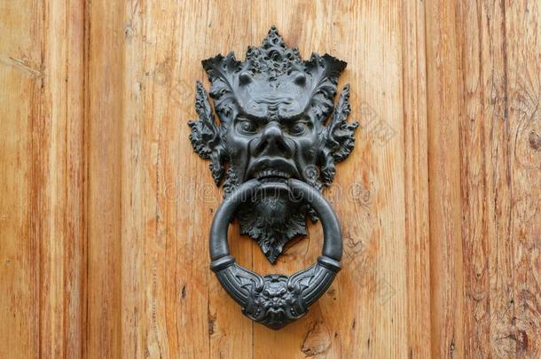 老的金属<strong>门门</strong>环和萨提尔人上端向一木制的门