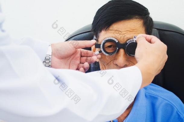 上了年纪的男人所有Hesper西方眼睛仔细检查在旁边一眼睛医生向一特斯蒂