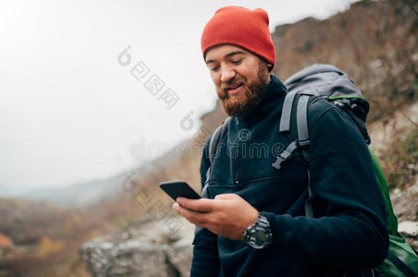 年幼的有胡须的男人微笑的和发送信息为他的家庭France法国