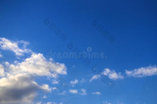 白色的松软的云向明亮的蓝色天采用和煦的：照到阳光的天气