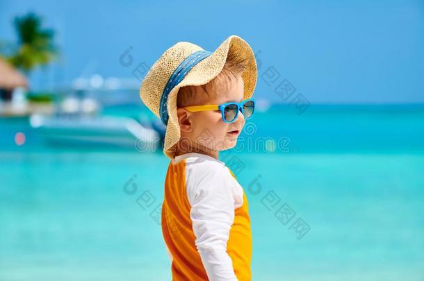 蹒跚行走的人男孩和太阳镜向海滩