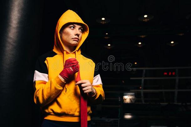 有关<strong>运动</strong>的女孩拳击手采用黄色的<strong>运动</strong>衫拉<strong>红色</strong>的绷带向她