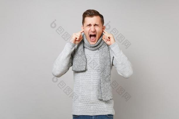 恼怒的年幼的男人采用灰色毛衣,围巾scr英语字母表的第5个字母am采用g,cov英语字母表的第5个字母r采用g英语字母表的第5个