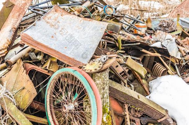 老的自行车轮子在指已提到的人倾倒,废料金属从家庭浪费,