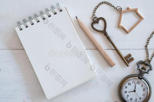 房屋钥匙和家钥匙ring,空白的笔记簿和铅笔向白色的
