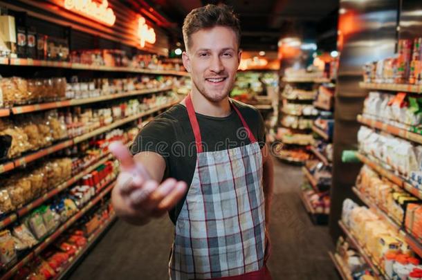 英俊的年幼的男人台采用食品杂货店商店经过面团架子.他