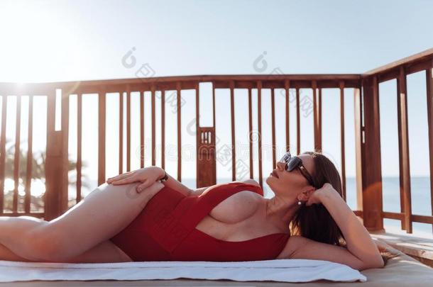 加大小女孩和体型富于曲线美的日光浴向指已提到的人海滩