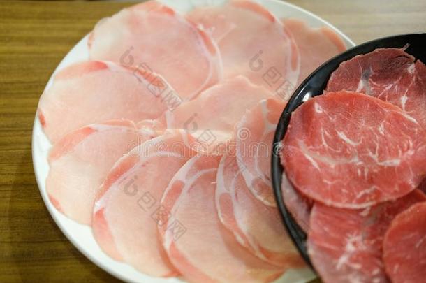 生的红色的牛肉和生的猪肉切成片为涮锅和<strong>寿喜烧</strong>日本人