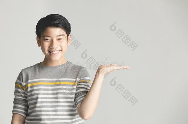亚洲人青春期前的十几岁的男孩道岔在上面越过灰色背景