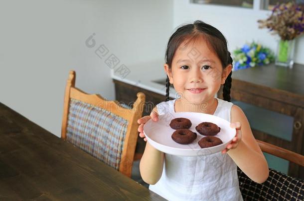 幸福的小的亚洲人小孩女孩展映盘子关于自家制的浓情巧克力